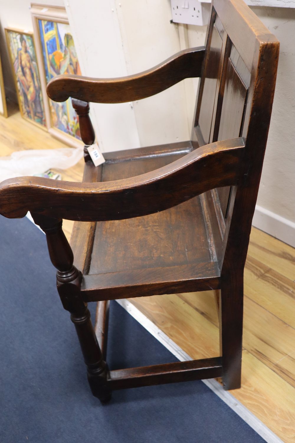 An 18th century oak panel back open armchair with wood seat,